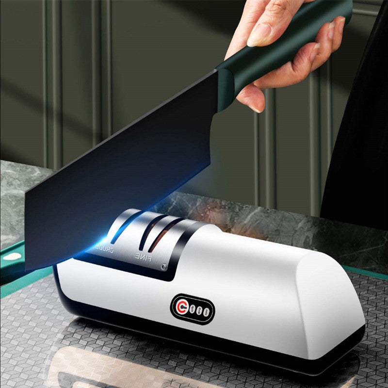 Electric knife sharpener with LED light sharpening chef knife on kitchen counter